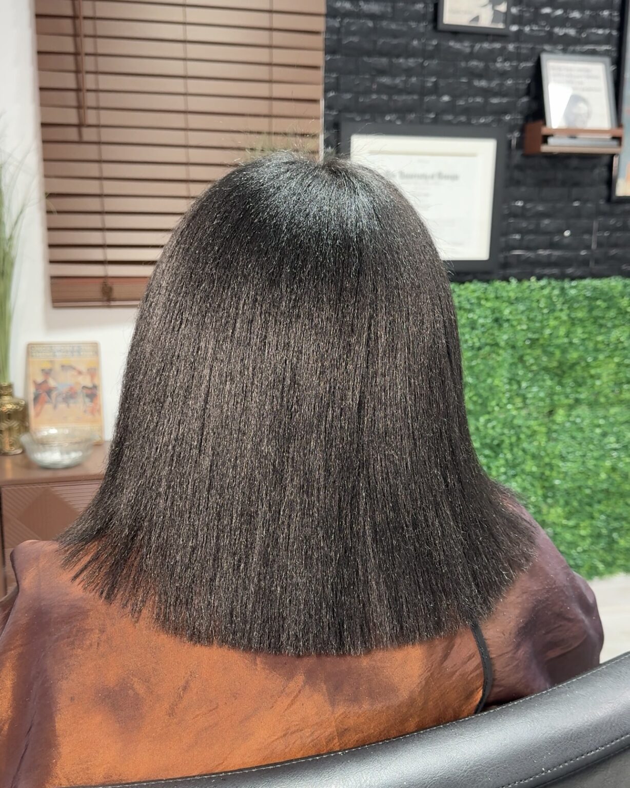 A woman with long hair sitting in front of a window.